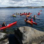 Pilvinen päivä, ihmisiä kanooteilla järvellä.