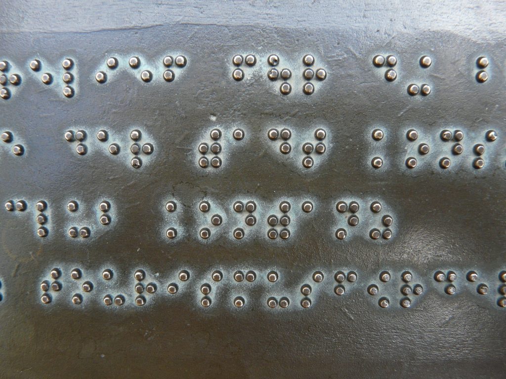 Pistekirjoitusta eli braillekirjoitusta metallilevylle painettun