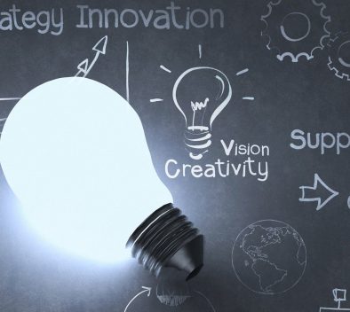 Liitutaulu, jossa on hehkulamppu ja sen ympärillä termejä: strategy innovation, vision creativity, support, solution.
